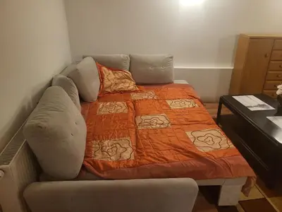 a bed and a couch with an orange blanket at Grzegorzecka Room 3 in Kraków