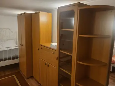 two wooden cabinets in a room with a bedroom at Grzegorzecka Room 3 in Kraków