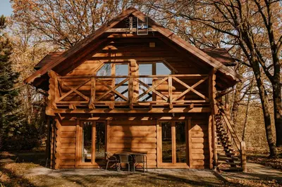a log cabin in the woods with a balcony at Sosnowy Domek Parter Zator Energylandia Graboszyce in Graboszyce