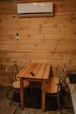 a table and chairs in a room with wooden walls at Sosnowy Domek Parter Zator Energylandia Graboszyce in Graboszyce