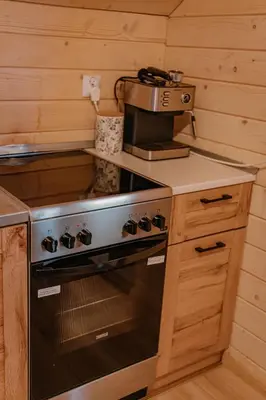 a kitchen with a stove and a coffee maker at Sosnowy Domek Parter Zator Energylandia Graboszyce in Graboszyce