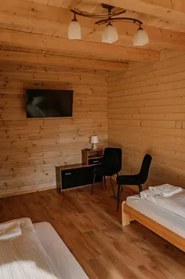 a bedroom with a television and a desk and two chairs at Sosnowy Domek Parter Zator Energylandia Graboszyce in Graboszyce