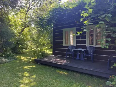 a cabin with a table and chairs on the porch at Staruszka Chata in Sidzina