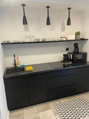 a kitchen with a black counter top and a sink at Dodo Acomodo 6 in Kraków