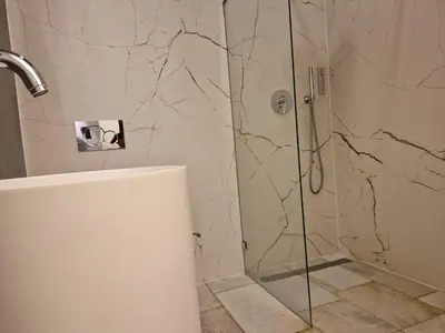 a shower with a glass door in a bathroom at Dodo Acomodo 6 in Kraków