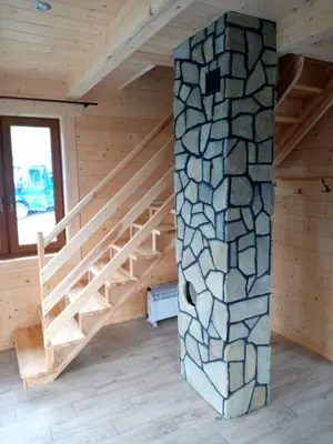 a staircase in a log cabin with a stone wall at Słoneczna Chata dom Kasina Wielka in Kasina Wielka