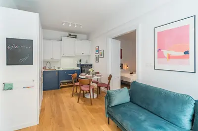 a living room with a blue couch and a table at Kraków Wawel Apartment - Top Location, Workspace - by Rentujemy in Kraków