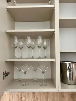 a row of wine glasses sitting on a shelf at Sebastiana Street Luxury Apartment in Kraków