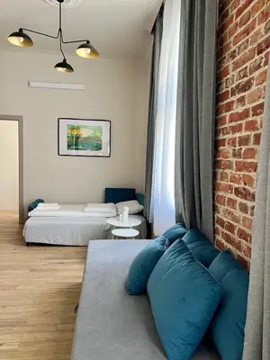 a room with two beds and a brick wall at Sebastiana Street Luxury Apartment in Kraków