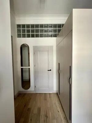 a hallway with a white door and a mirror at Sebastiana Street Luxury Apartment in Kraków