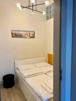 a bed in a room with a picture on the wall at Sebastiana Street Luxury Apartment in Kraków