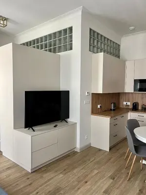 a living room with a tv on a white wall at Sebastiana Street Luxury Apartment in Kraków
