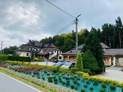 a house with a garden with flowers in the street at Hotel Pod Kamieniem in Lipnica Murowana