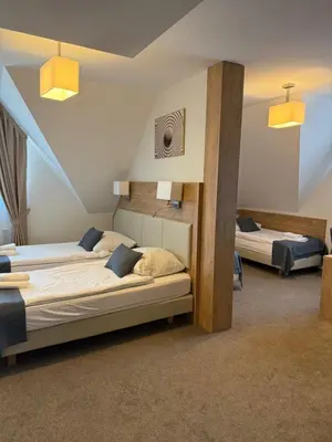 a bedroom with two beds in a attic at Hotel Pod Kamieniem in Lipnica Murowana