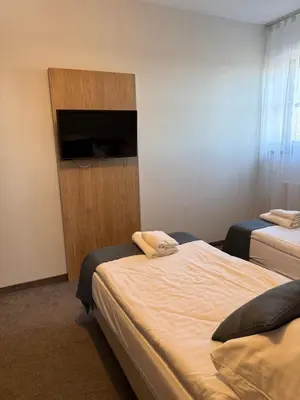 a room with two beds and two night stands at Hotel Pod Kamieniem in Lipnica Murowana
