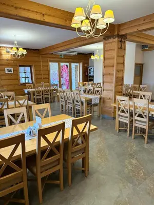 a dining room with wooden tables and chairs at Hotel Pod Kamieniem in Lipnica Murowana