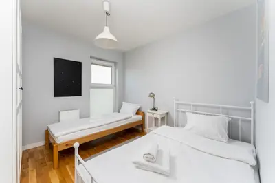 a bedroom with two beds and a tv at Krowodrza 2-Bedroom Apartment by BookingHost in Kraków