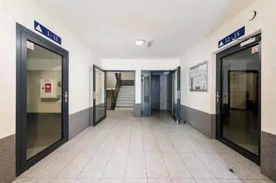 an empty hallway of a building with glass doors at Krowodrza 2-Bedroom Apartment by BookingHost in Kraków