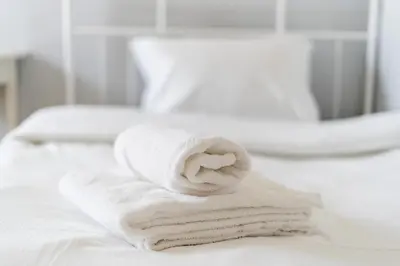 a stack of towels sitting on top of a bed at Krowodrza 2-Bedroom Apartment by BookingHost in Kraków