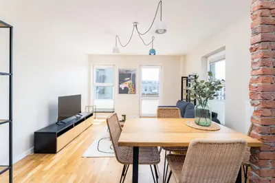 a dining room and living room with a table and chairs at Krowodrza 2-Bedroom Apartment by BookingHost in Kraków