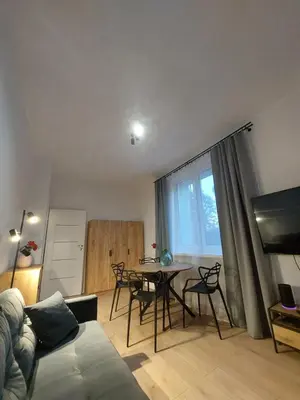 a living room with a table and chairs and a couch at Apartament Aleja 29 Listopada in Kraków