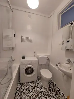 a white bathroom with a toilet and a sink at Apartament Aleja 29 Listopada in Kraków
