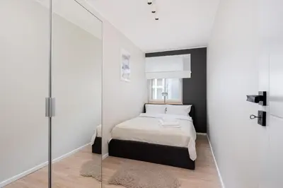 a bedroom with a bed and a glass wall at Old Town Modern Apartment by BookingHost in Kraków