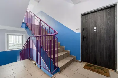 a staircase with a purple railing next to a door at Old Town Modern Apartment by BookingHost in Kraków