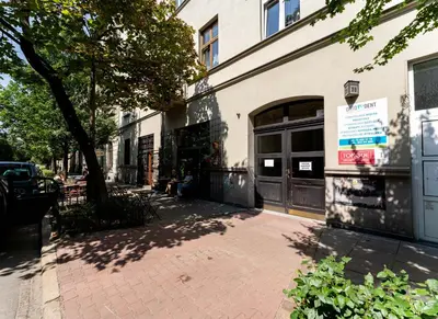 a person sitting on a sidewalk in front of a building at Old Town Spacious Apartment by BookingHost in Kraków