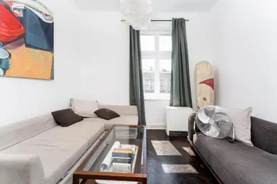 a living room with two couches and a surfboard at Old Town Spacious Apartment by BookingHost in Kraków