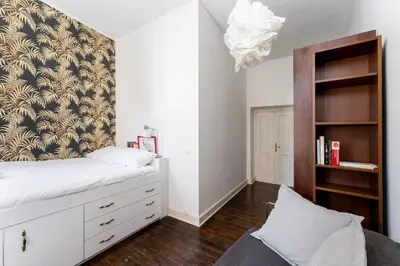 a bedroom with a white bed and a book shelf at Old Town Spacious Apartment by BookingHost in Kraków