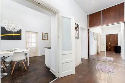 a dining room with a table and a white door at Old Town Spacious Apartment by BookingHost in Kraków