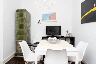 a white dining room with a white table and white chairs at Old Town Spacious Apartment by BookingHost in Kraków