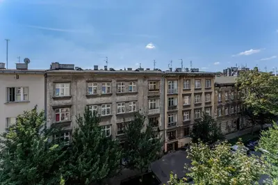 a large brick building with trees in front of it at Old Town Spacious Apartment by BookingHost in Kraków