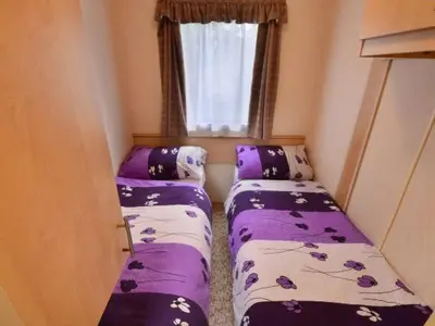 a small room with two beds and a window at Anser Collis in Wadowice