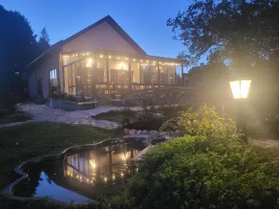 a house with a pond in the yard at night at Anser Collis in Wadowice