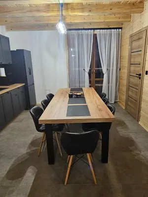 a kitchen with a wooden table and chairs at Domek Pod Skarpą in Wieprzec