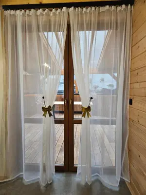 a pair of curtains in front of a door at Domek Pod Skarpą in Wieprzec