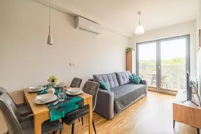 a living room with a table and a couch at Kraków Old Town - Bus&Tram Stops Nearby, Balcony - by Rentujemy in Kraków