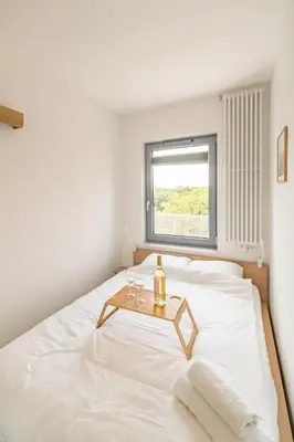 a bedroom with a white bed with a table on it at Kraków Old Town - Bus&Tram Stops Nearby, Balcony - by Rentujemy in Kraków