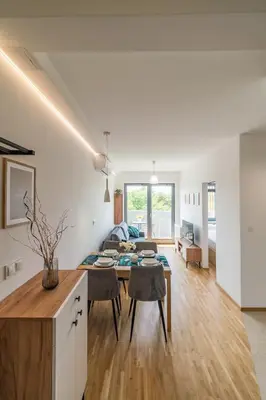 a kitchen and living room with a table and chairs at Kraków Old Town - Bus&Tram Stops Nearby, Balcony - by Rentujemy in Kraków
