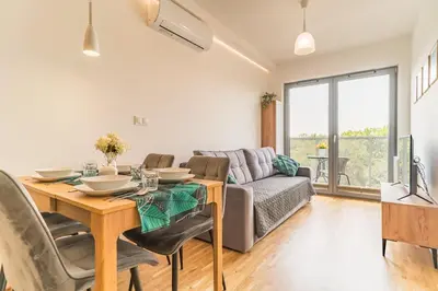 a living room with a table and a couch at Kraków Old Town - Bus&Tram Stops Nearby, Balcony - by Rentujemy in Kraków