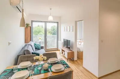 a living room with a table and a couch at Kraków Old Town - Bus&Tram Stops Nearby, Balcony - by Rentujemy in Kraków