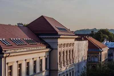 a building with a tiled roof next to other buildings at SAW! KRAKÓW Apartments - Studencka in Kraków