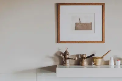 a picture frame above a kitchen counter with brass faucets at SAW! KRAKÓW Apartments - Studencka in Kraków