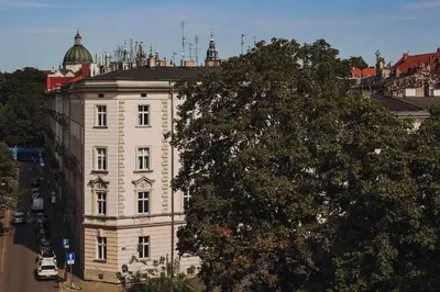a large white building with a tree in front of it at SAW! KRAKÓW Apartments - Studencka in Kraków