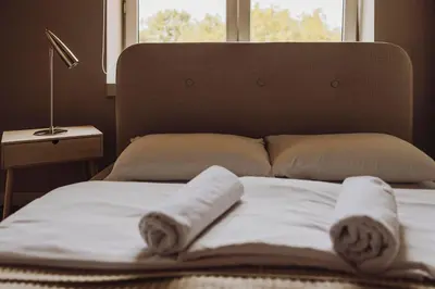 a bed with towels on it with a window at SAW! KRAKÓW Apartments - Studencka in Kraków