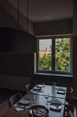 a table with wine glasses and a window at SAW! KRAKÓW Apartments - Studencka in Kraków