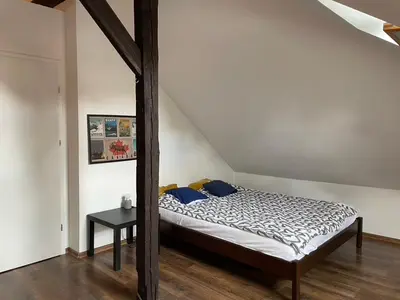 a bedroom with a bed and a table in it at Piekny,duzy loft 80 metrow blisko centrum in Kraków