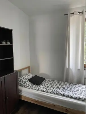 a bed in a room with a curtain and a window at Piekny,duzy loft 80 metrow blisko centrum in Kraków